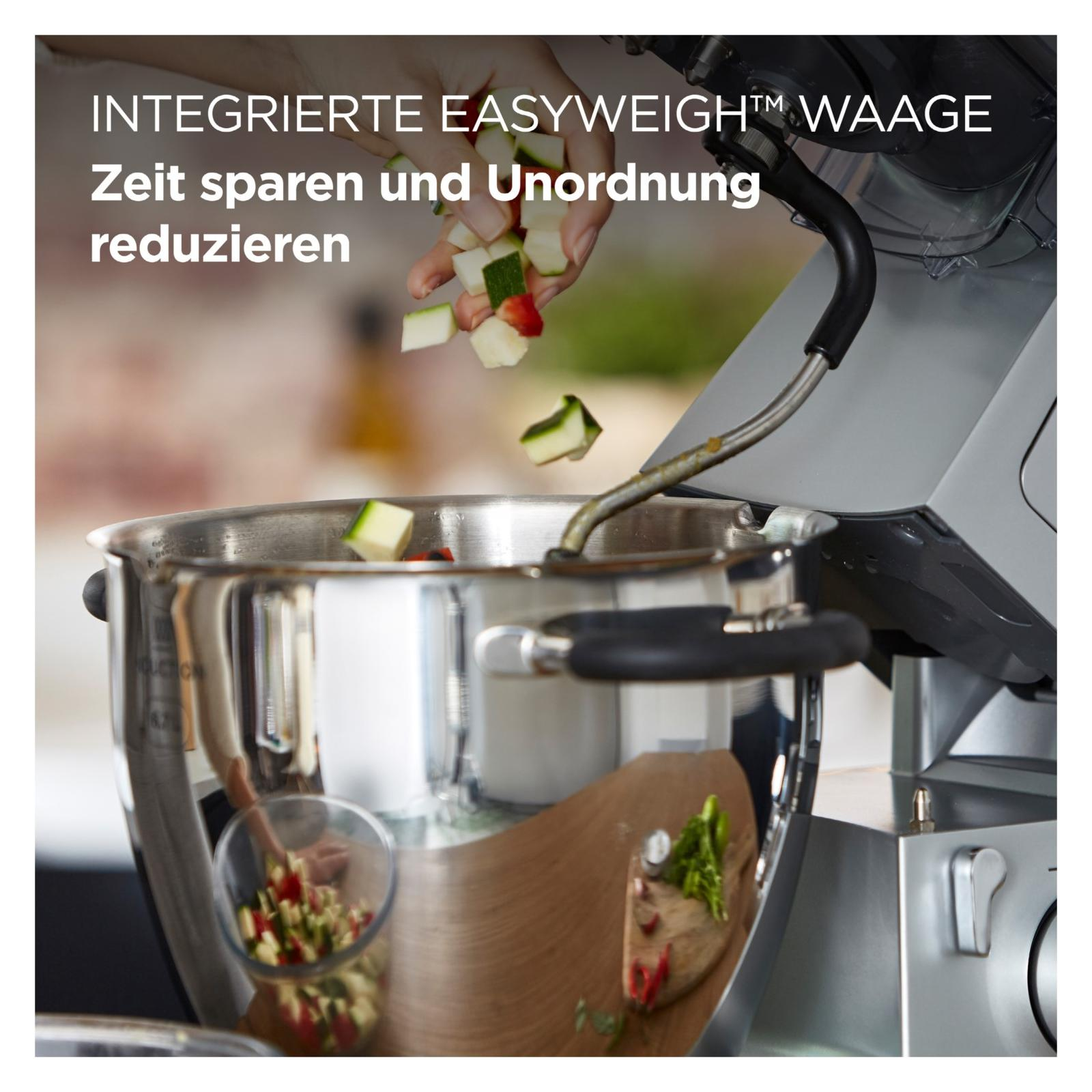 Zutaten fallen in eine Rührschüssel neben einer Küchenmaschine.