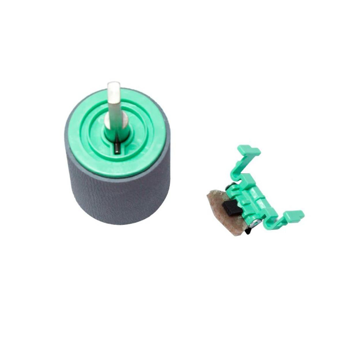 Rullo in gomma grigia con mozzo verde e albero metallico; piccola clip in plastica verde con parte marrone.