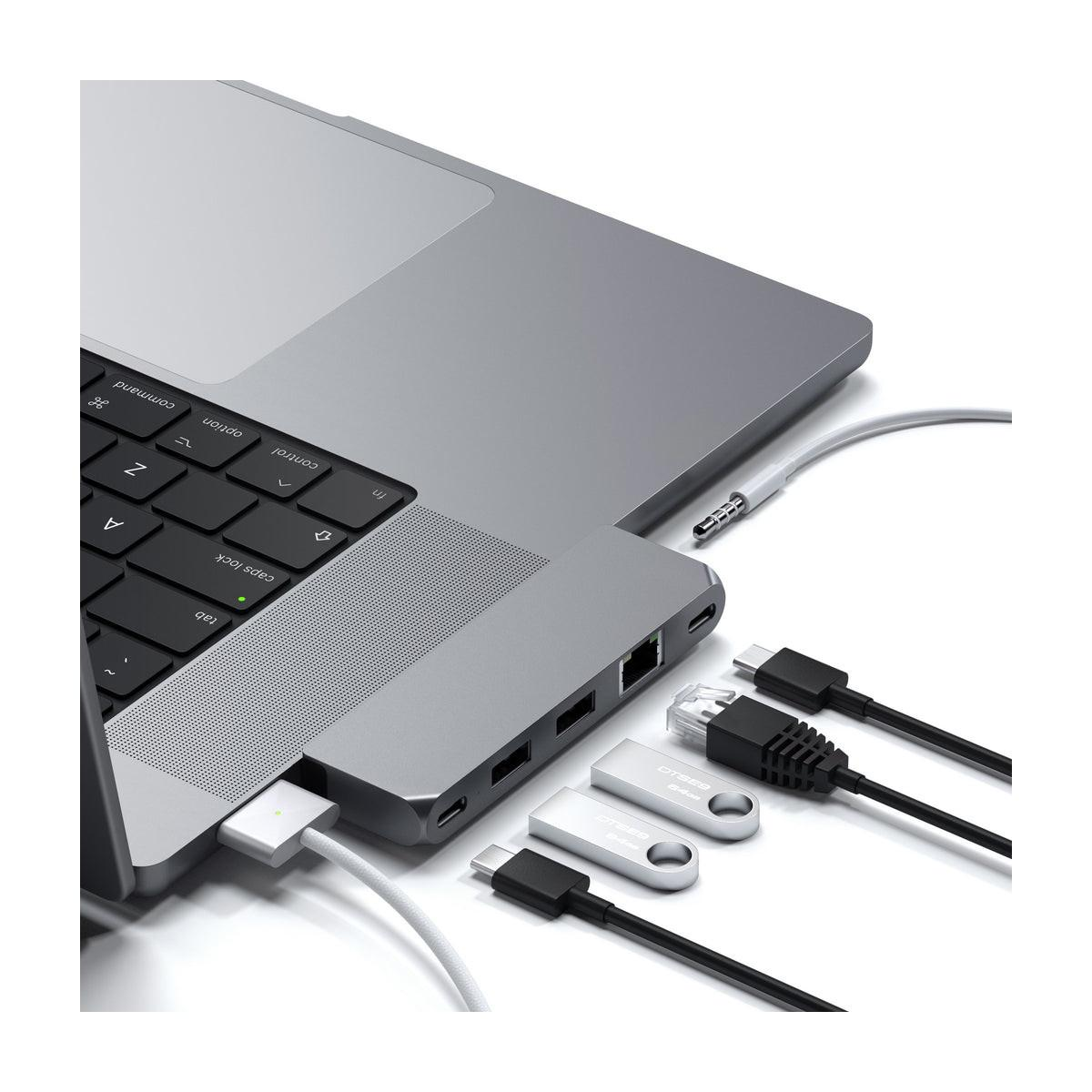 Un laptop con hub di docking, unità USB e cavi collegati.