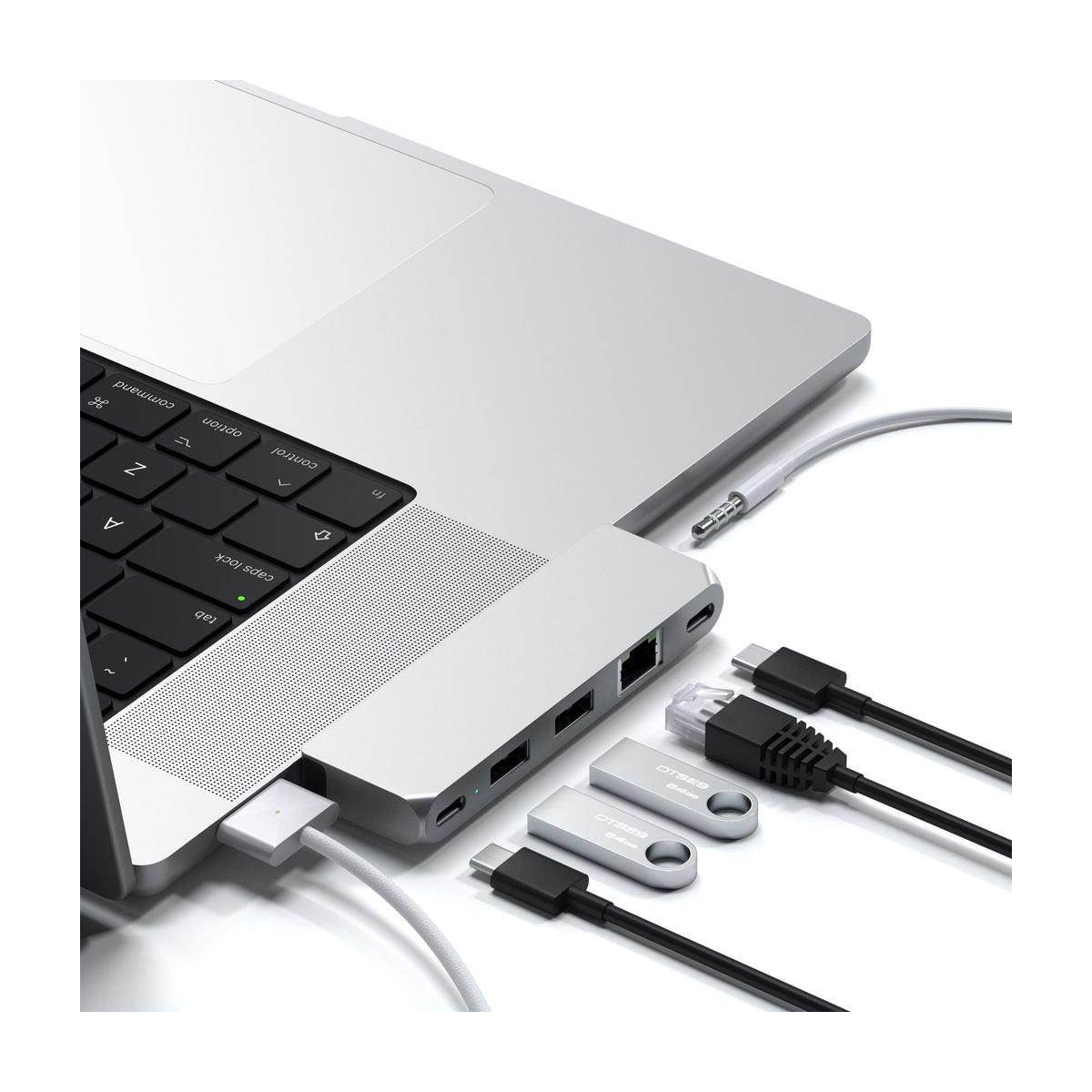 Laptop mit silbernem Hub, verbundenen Kabeln, USB-Sticks und Ethernet-Kabel.