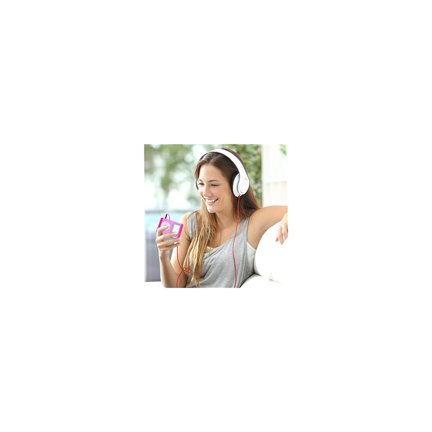 Frau mit Kopfhörern hört Musik auf einem rosa MP3-Player, lächelt.
