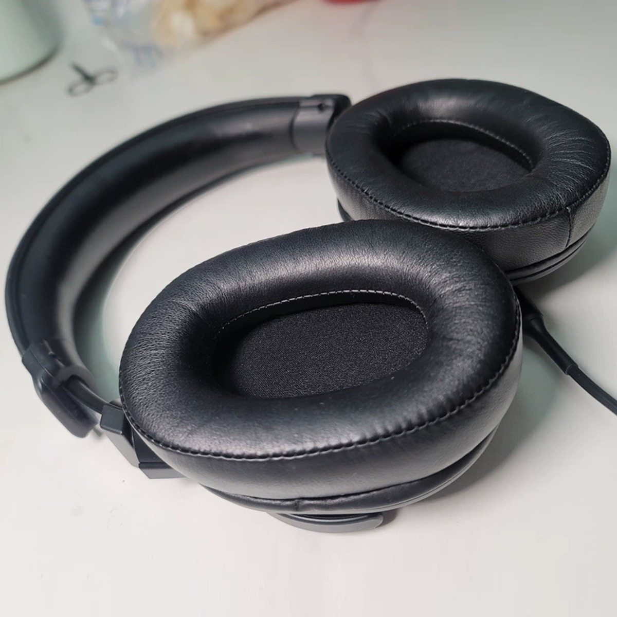 Schwarze Over-Ear-Kopfhörer mit gepolsterten Ohrmuscheln und verstellbarem Kopfbügel.