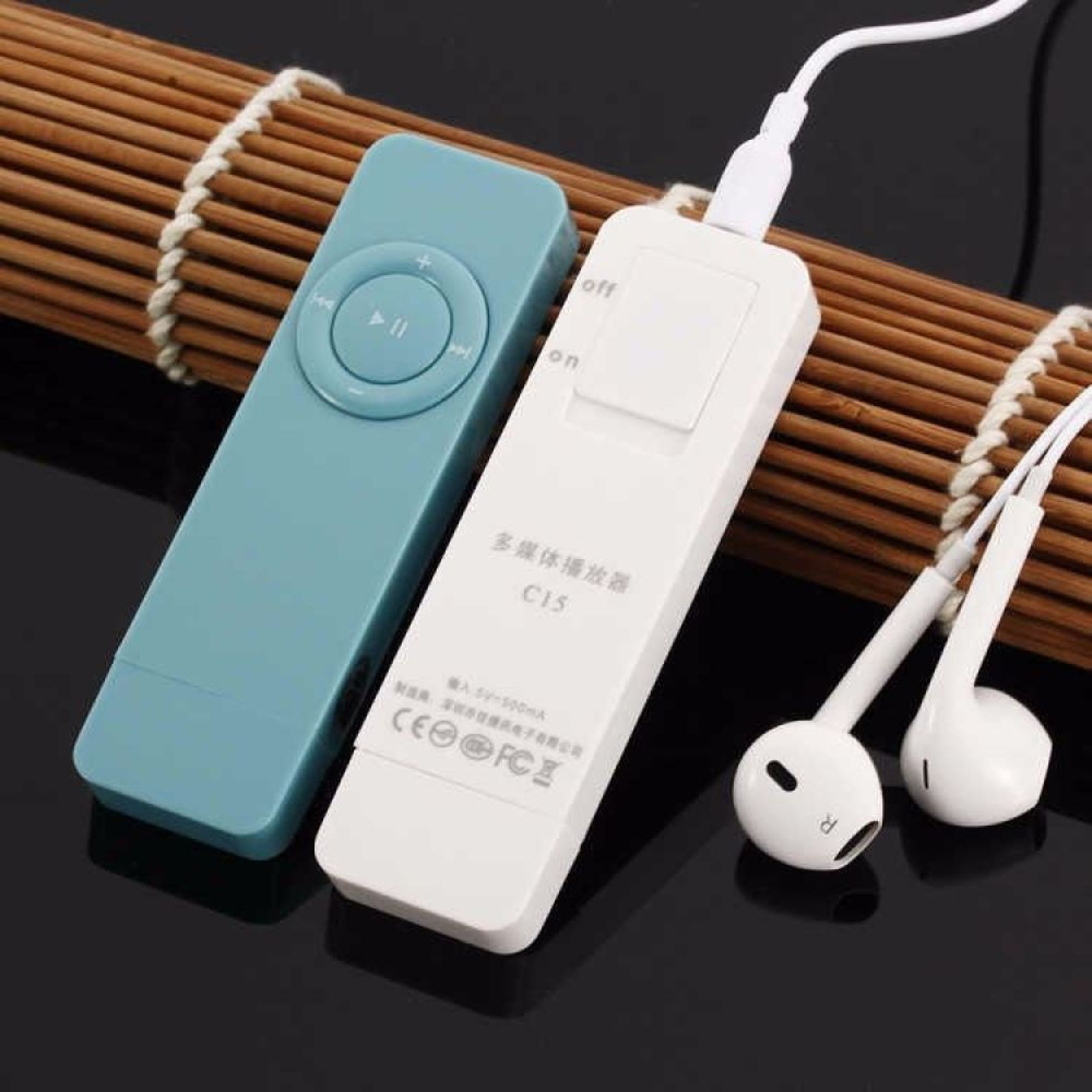 Ein blauer und ein weißer MP3-Player mit Kopfhörern auf einem Bambusuntergrund.