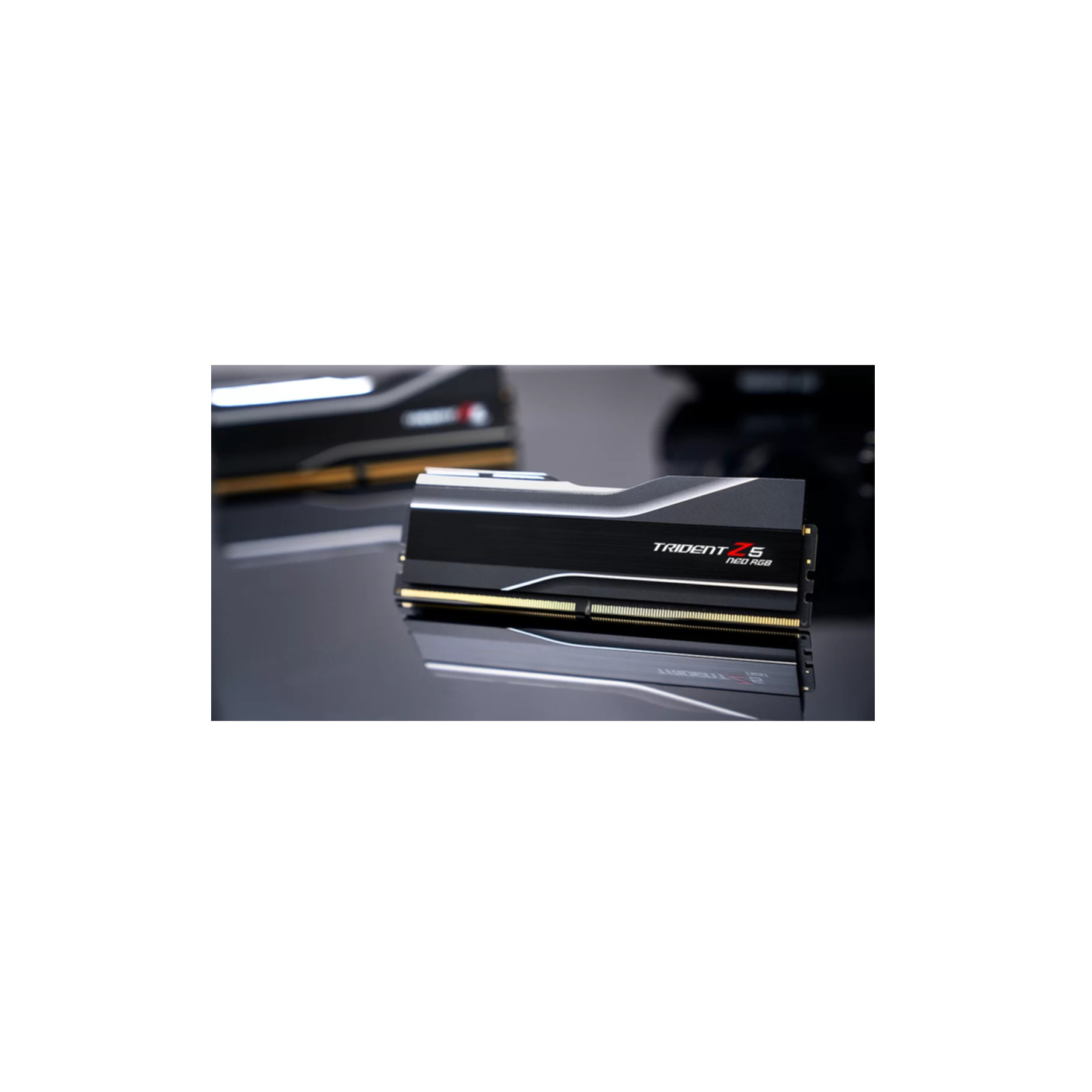 Un modulo RAM nero con accenti argentati e contatti dorati su una superficie riflettente.