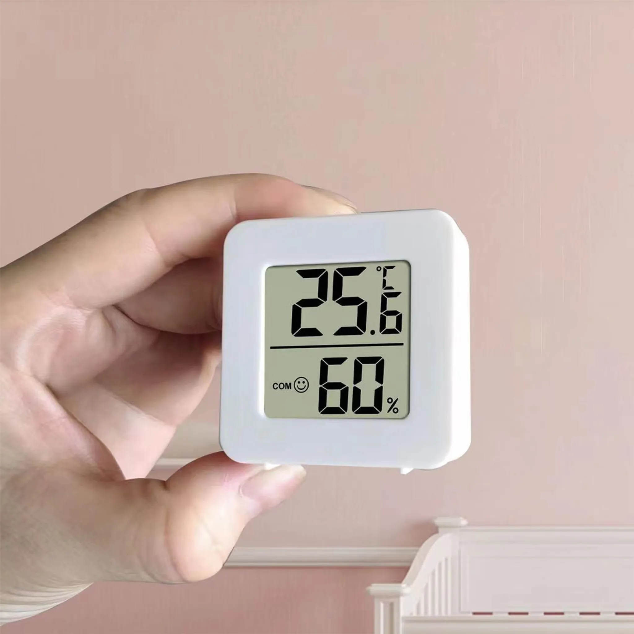 Ein weißes Digitalthermometer zeigt 25,6°C und 60% Luftfeuchtigkeit an.