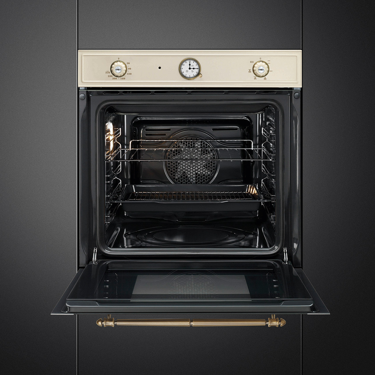 Un horno empotrado abierto con panel de control color crema y tirador dorado sobre fondo negro.