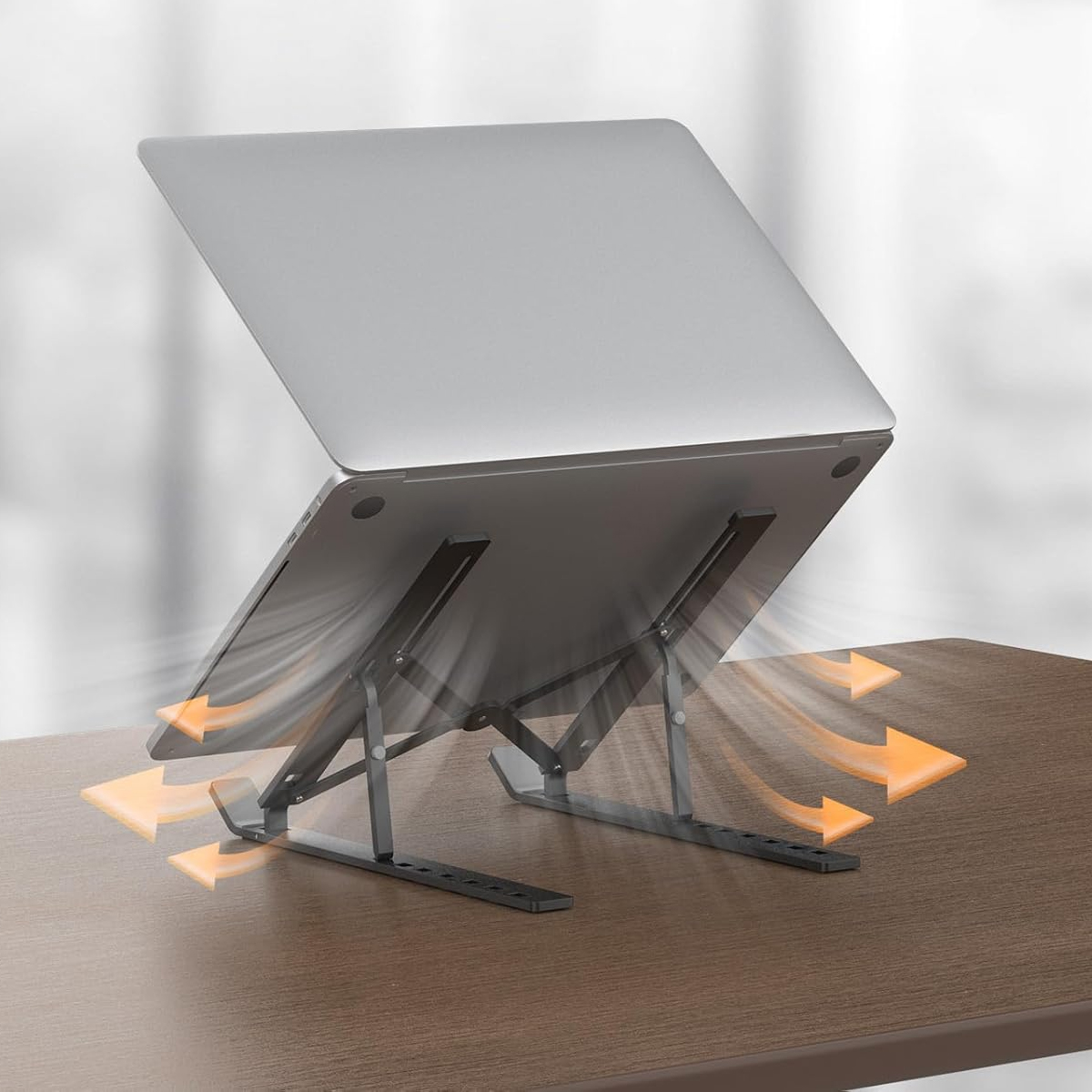Ein silberner Laptop steht auf einem schwarzen Ständer, orange Pfeile zeigen Luftstrom.