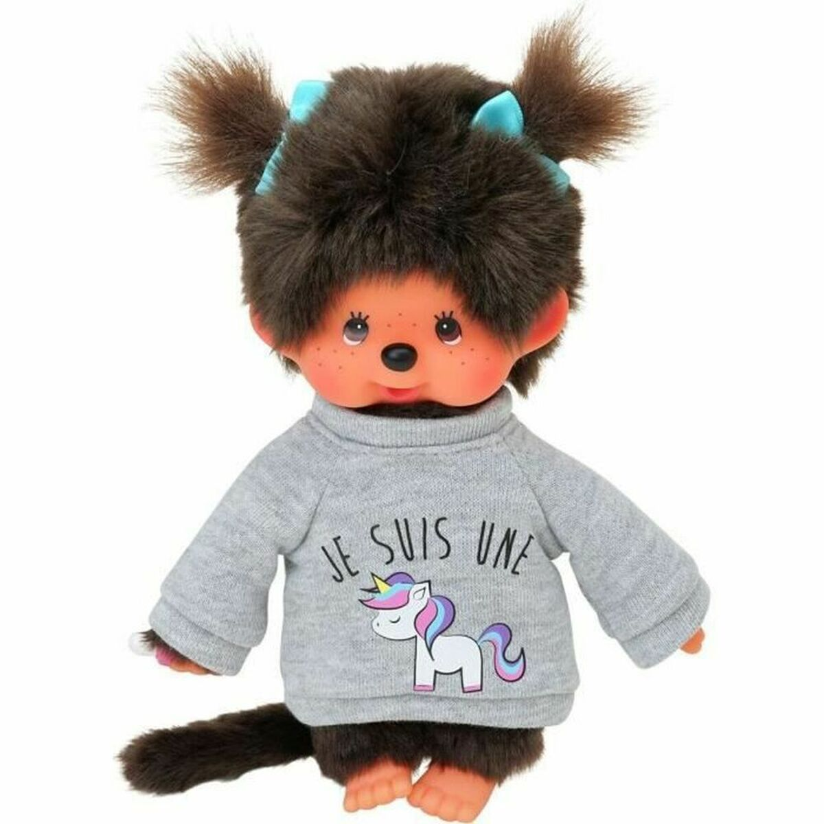 Una Monchhichi bambina con pelliccia marrone, fiocchi blu e maglione unicorno.