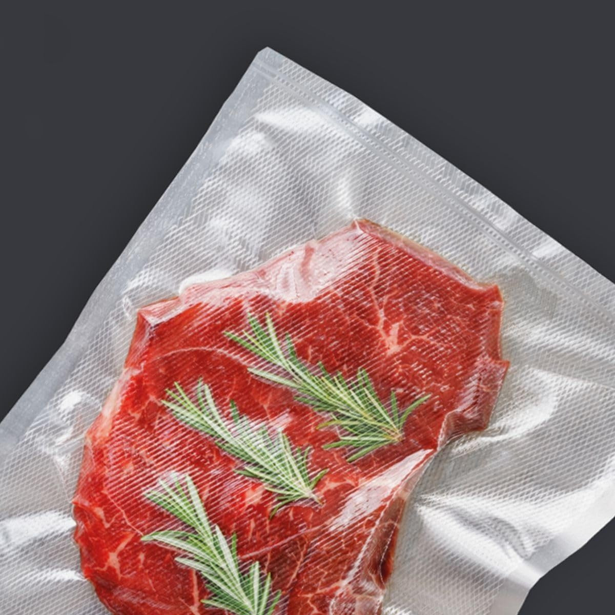 Rohes Steak mit Rosmarin in Vakuumbeutel auf grauem Hintergrund.