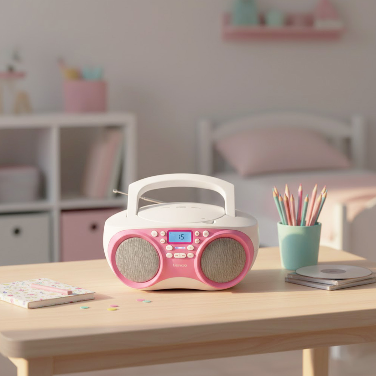 Ein rosa und weier CD-Player mit Lautsprechern steht auf einem Holztisch.