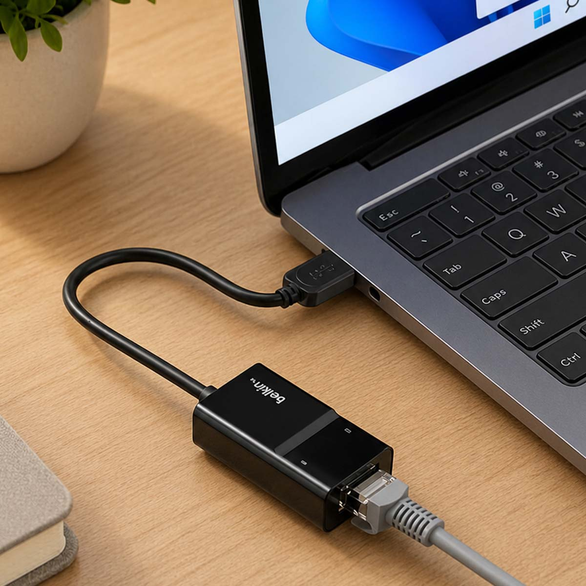 Un adaptador Ethernet negro está conectado a un portátil.