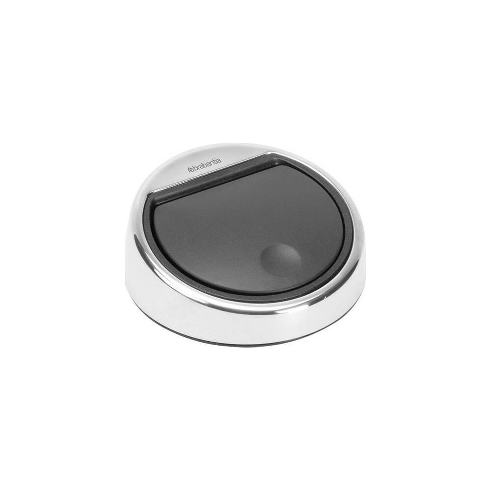 Een zilveren prullenbak met zwart deksel en Brabantia logo.