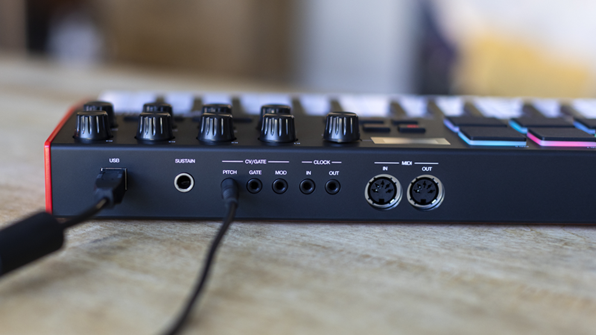 Czarny sprzęt audio z pokrętłami i portami, w tym złączami USB i MIDI.