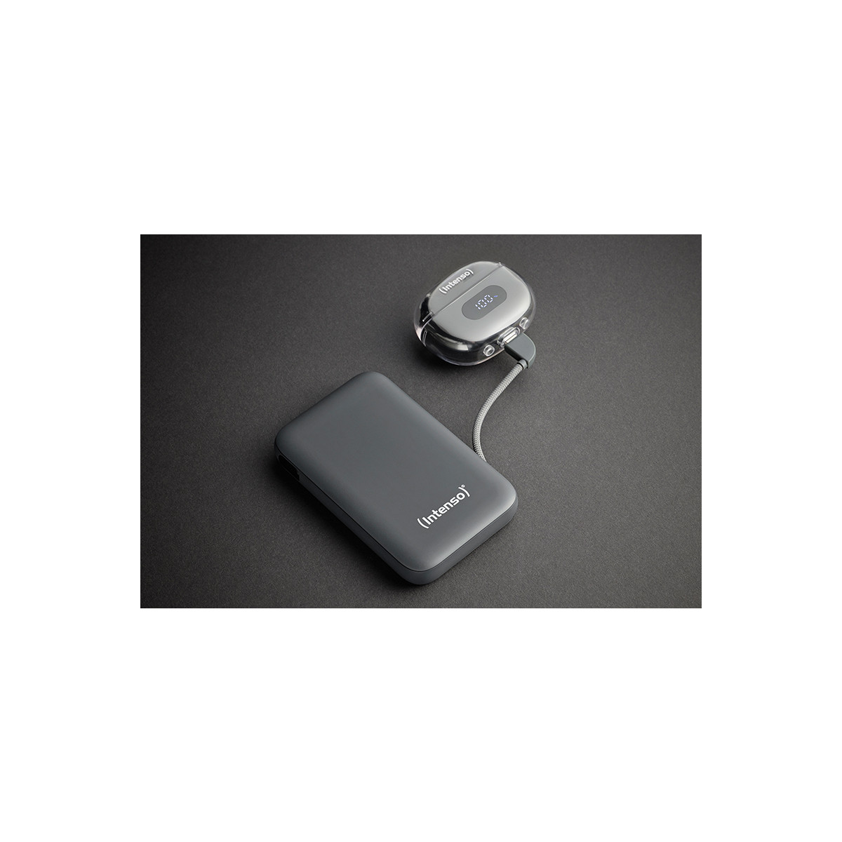 Power bank grigia e dispositivo associato con cavo su sfondo scuro.