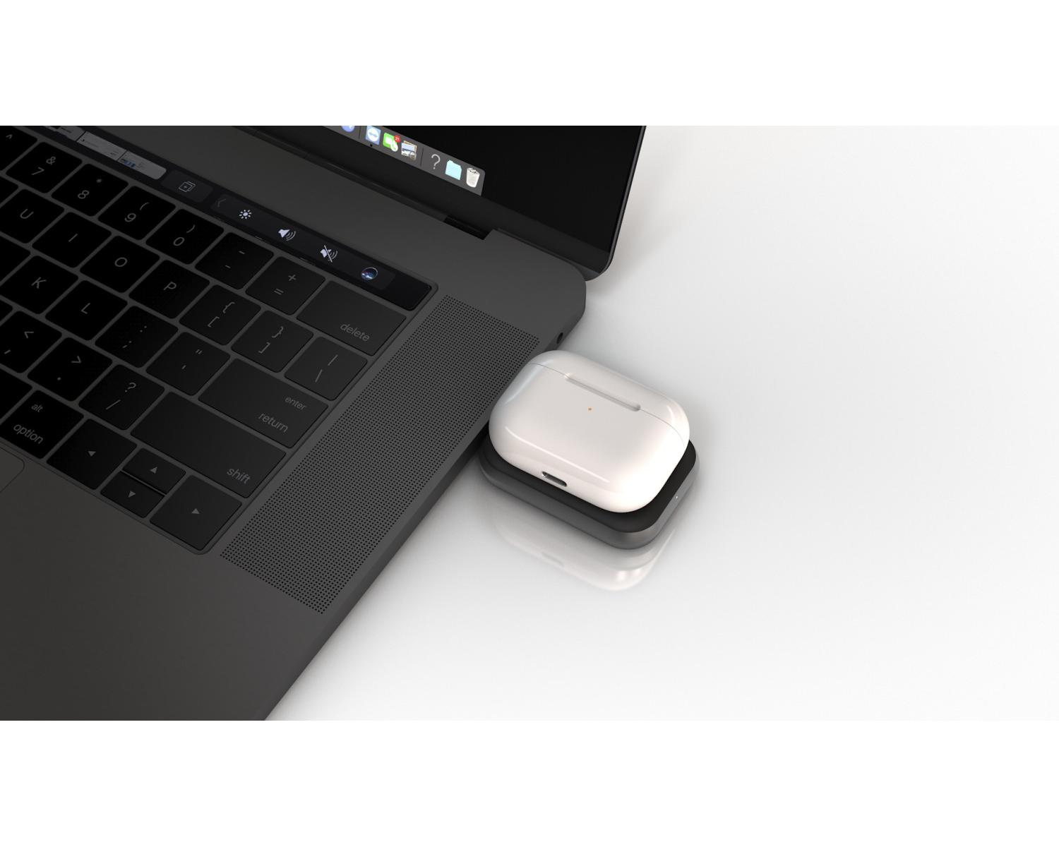 Ein Laptop mit einer weißen Ohrhörerhülle auf einem schwarzen Ladegerät. Der Laptop ist geöffnet.