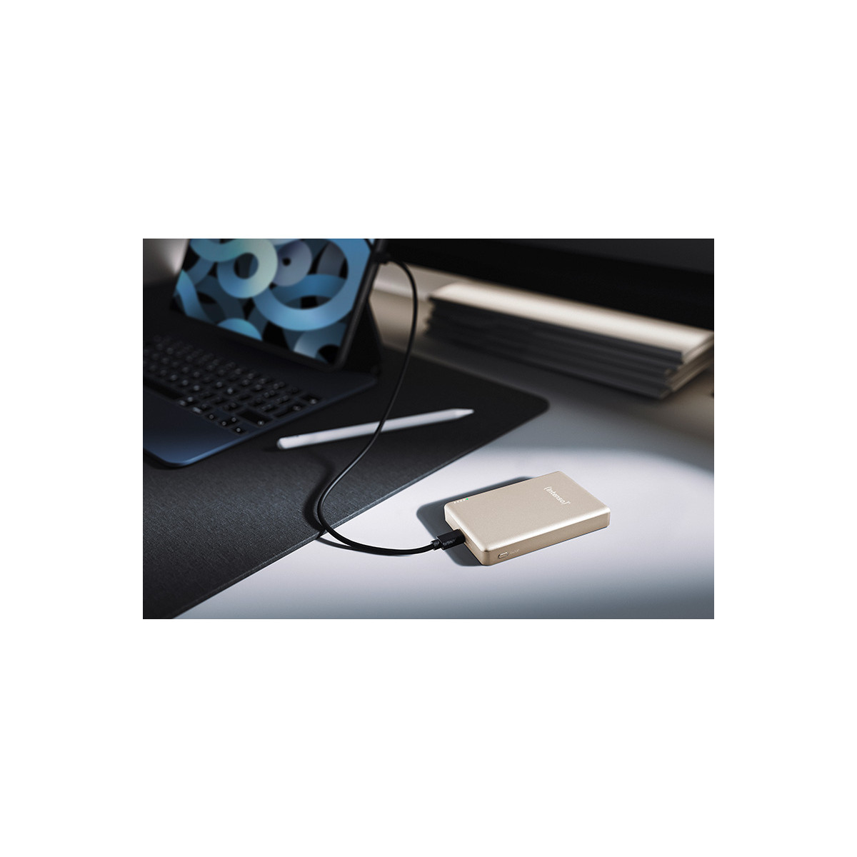Una batteria esterna dorata collegata a un tablet con tastiera e stilo.