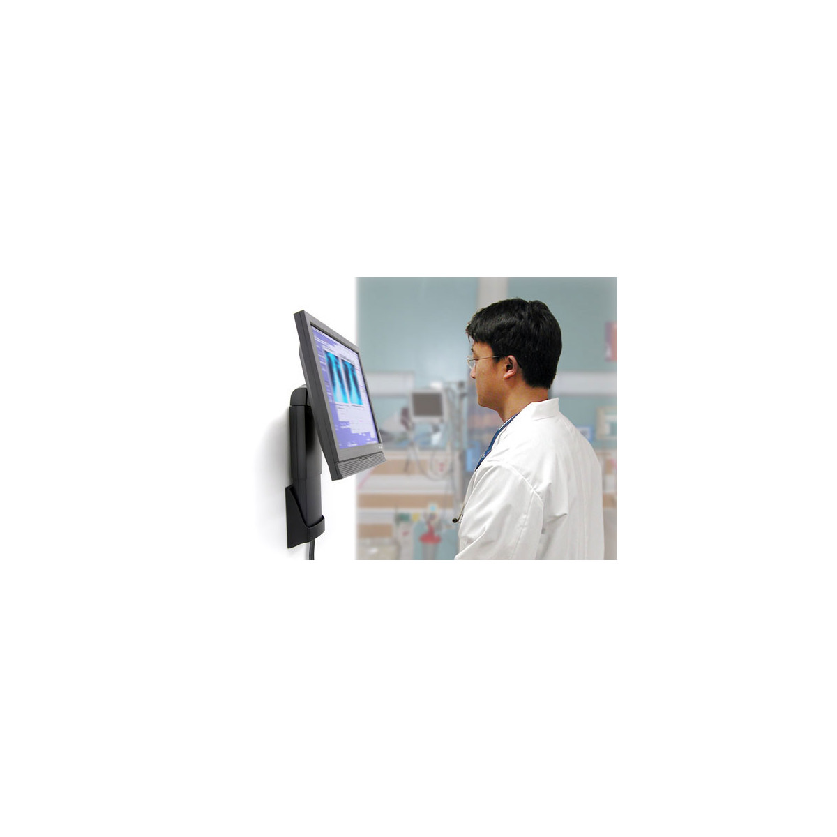 Un medico in camice bianco guarda un monitor che visualizza dati medici.