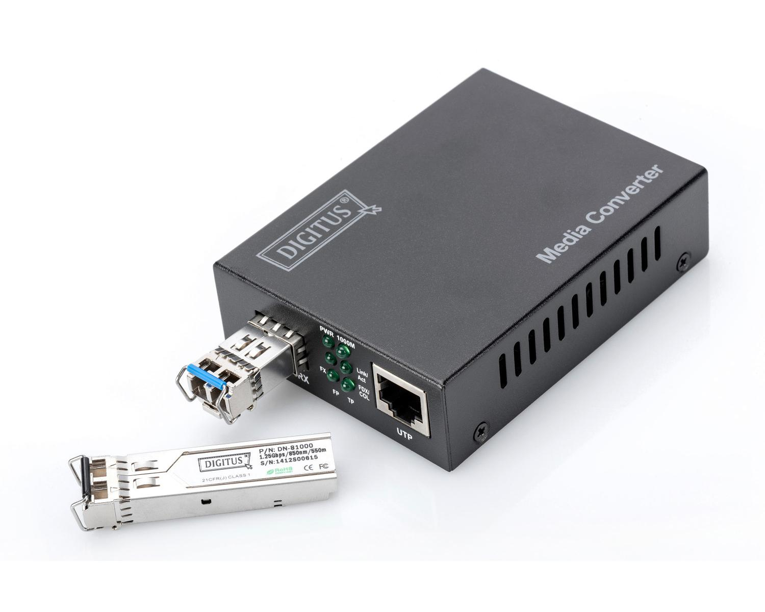 Black media converter with SFP module. One module is attached, another lies beside it.
