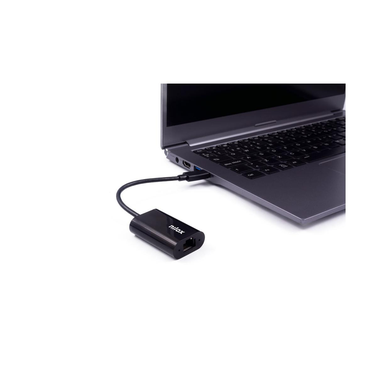 Un adaptador negro conecta un cable USB-C a un portátil.