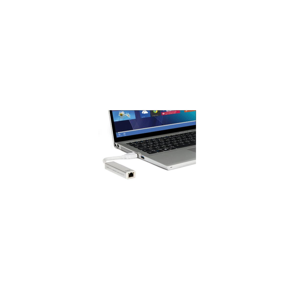 Un adaptador USB a Ethernet plateado está conectado a una computadora portátil.