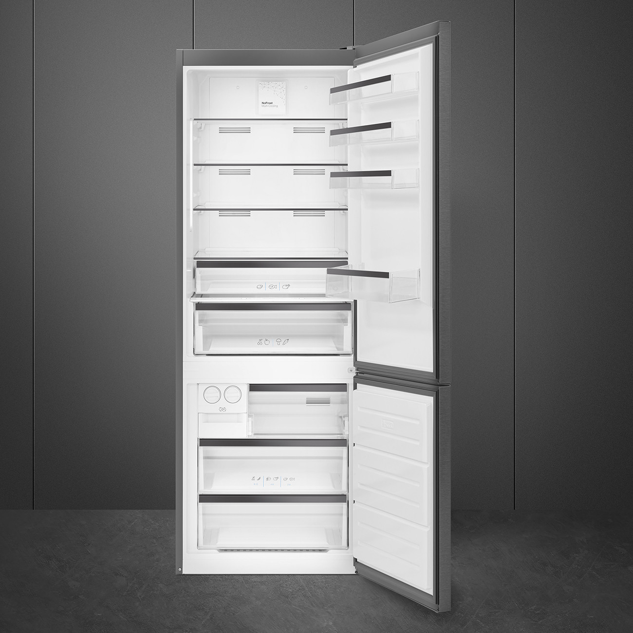 Refrigerador abierto con estantes y cajones vacíos contra pared gris oscuro.