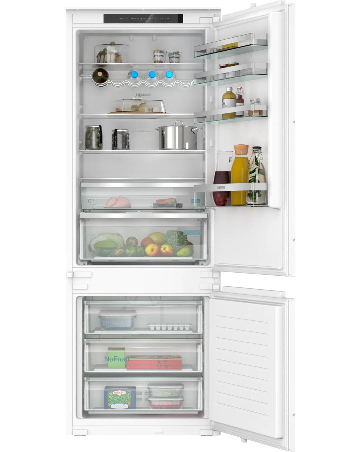 Un refrigerador Siemens blanco con la puerta abierta, lleno de alimentos.