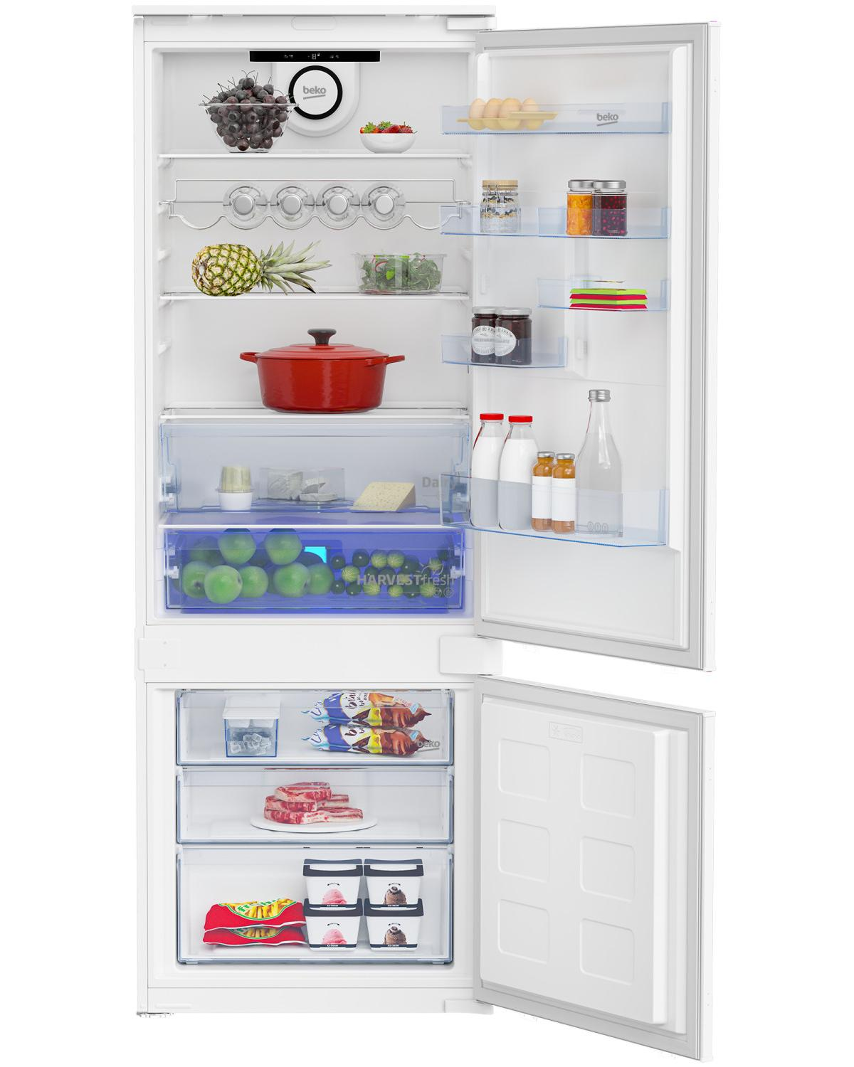 Un refrigerador blanco abierto con alimentos, incluyendo frutas, verduras, carne y helado.