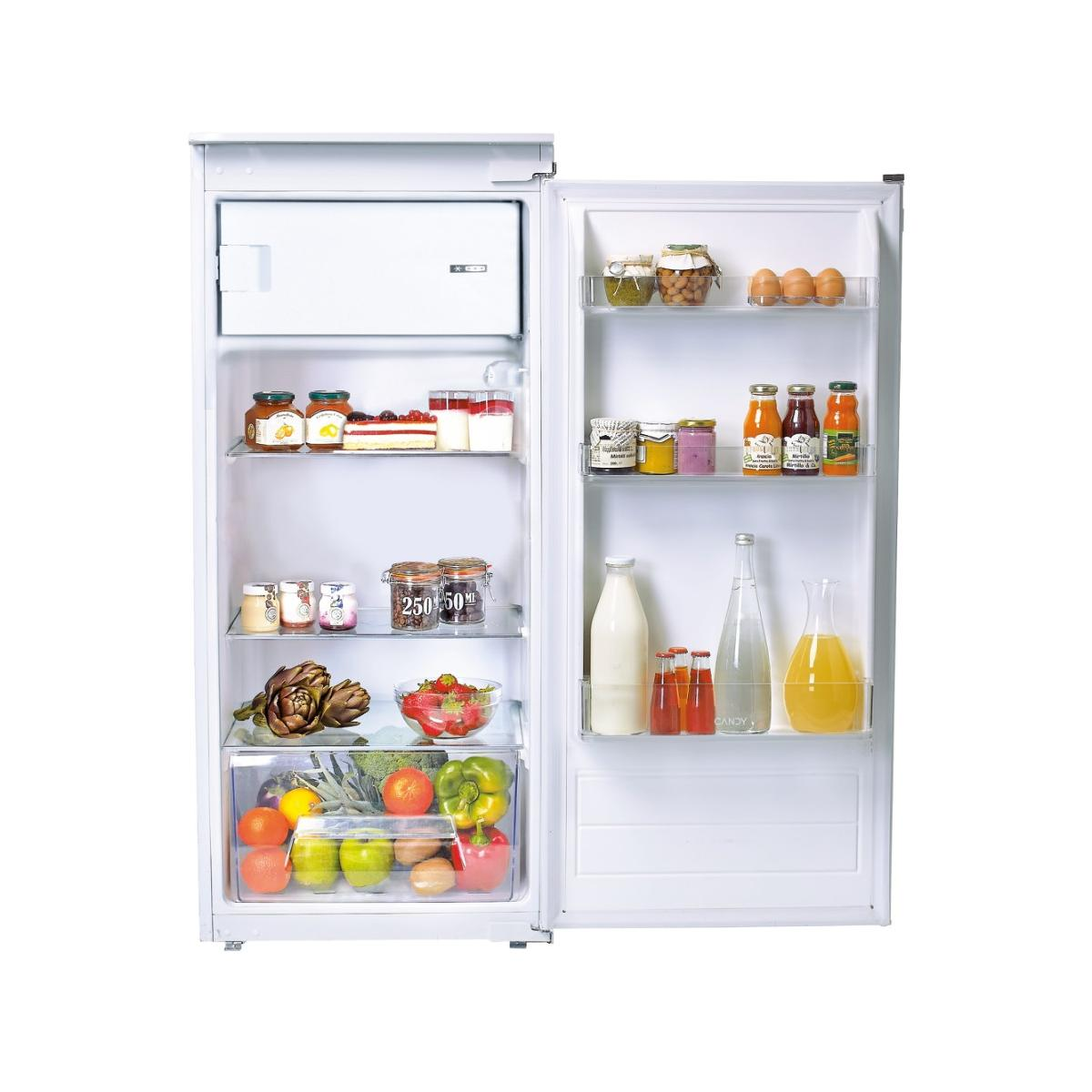 Un refrigerador blanco abierto lleno de comida: frutas, verduras, pastel, huevos, mermelada, jugo.