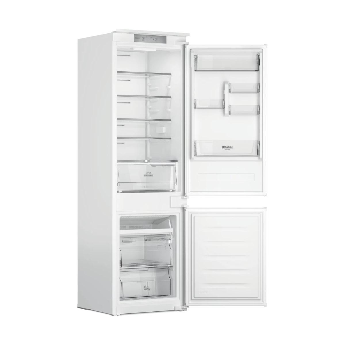 Een witte koelkast met de deur open, met planken en lades.