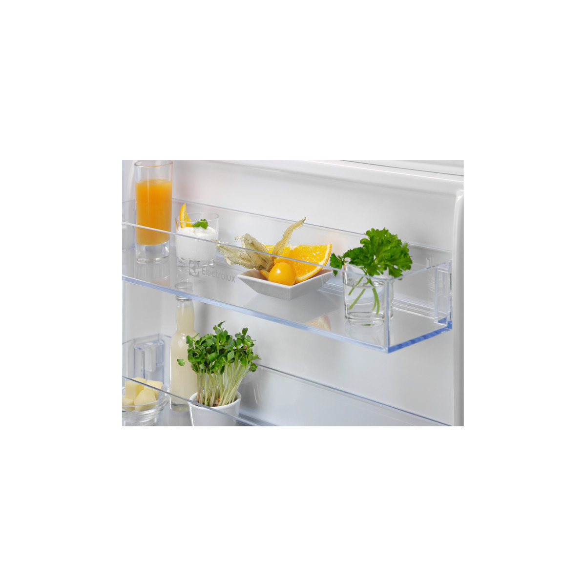 All'interno di un frigorifero: succo d'arancia, yogurt, frutta, germogli e prezzemolo.
