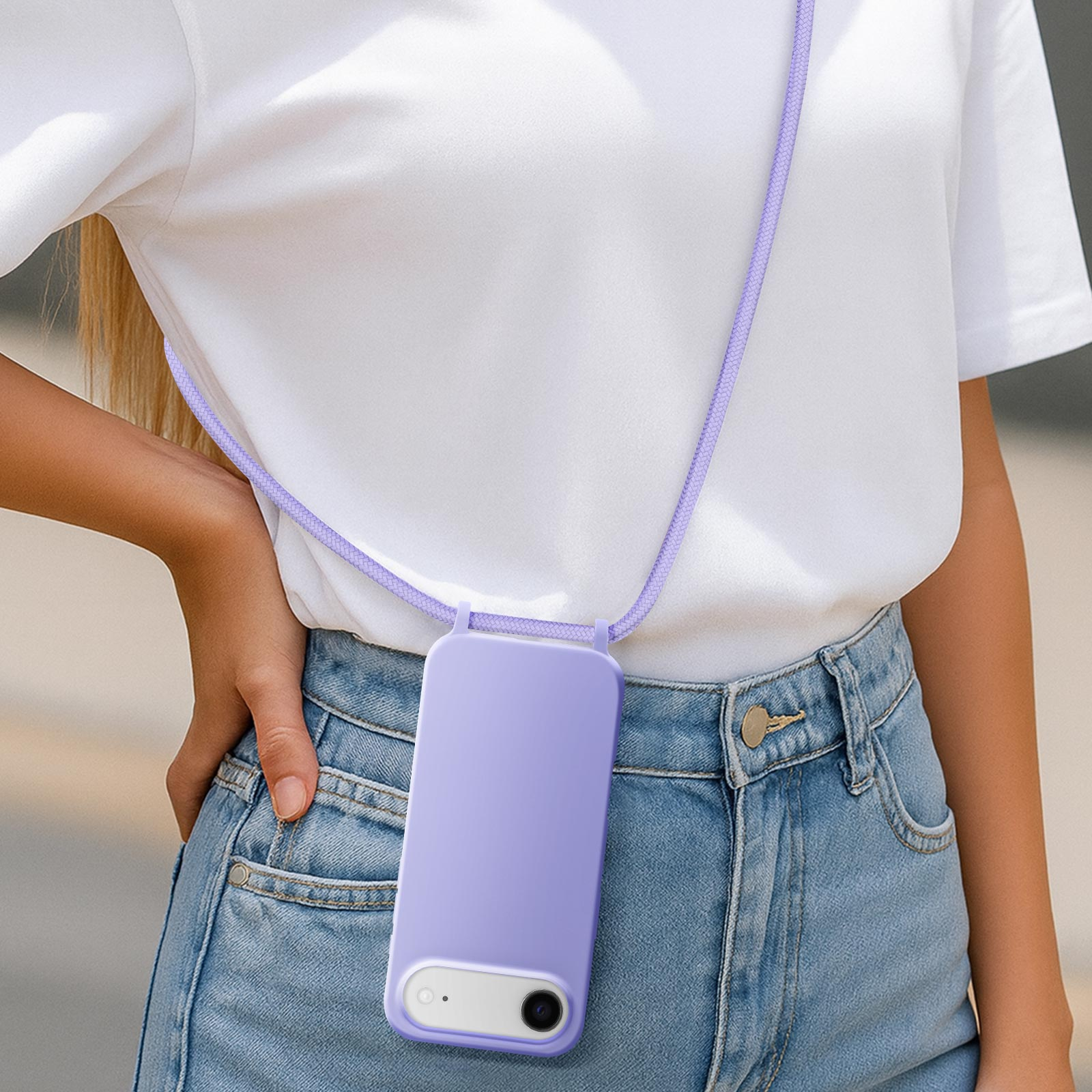 Una persona indossa una custodia viola per telefono con cordino su una maglietta bianca e jeans.