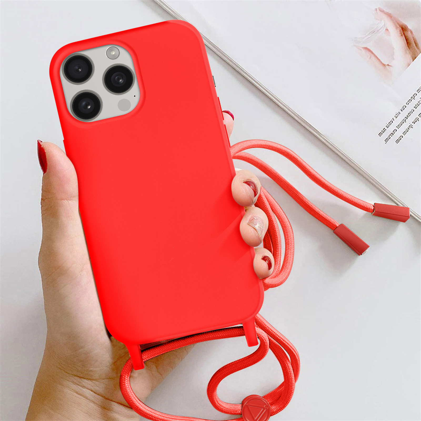 Cover rossa per telefono con sistema di fotocamere e cinturino, tenuta da una mano.