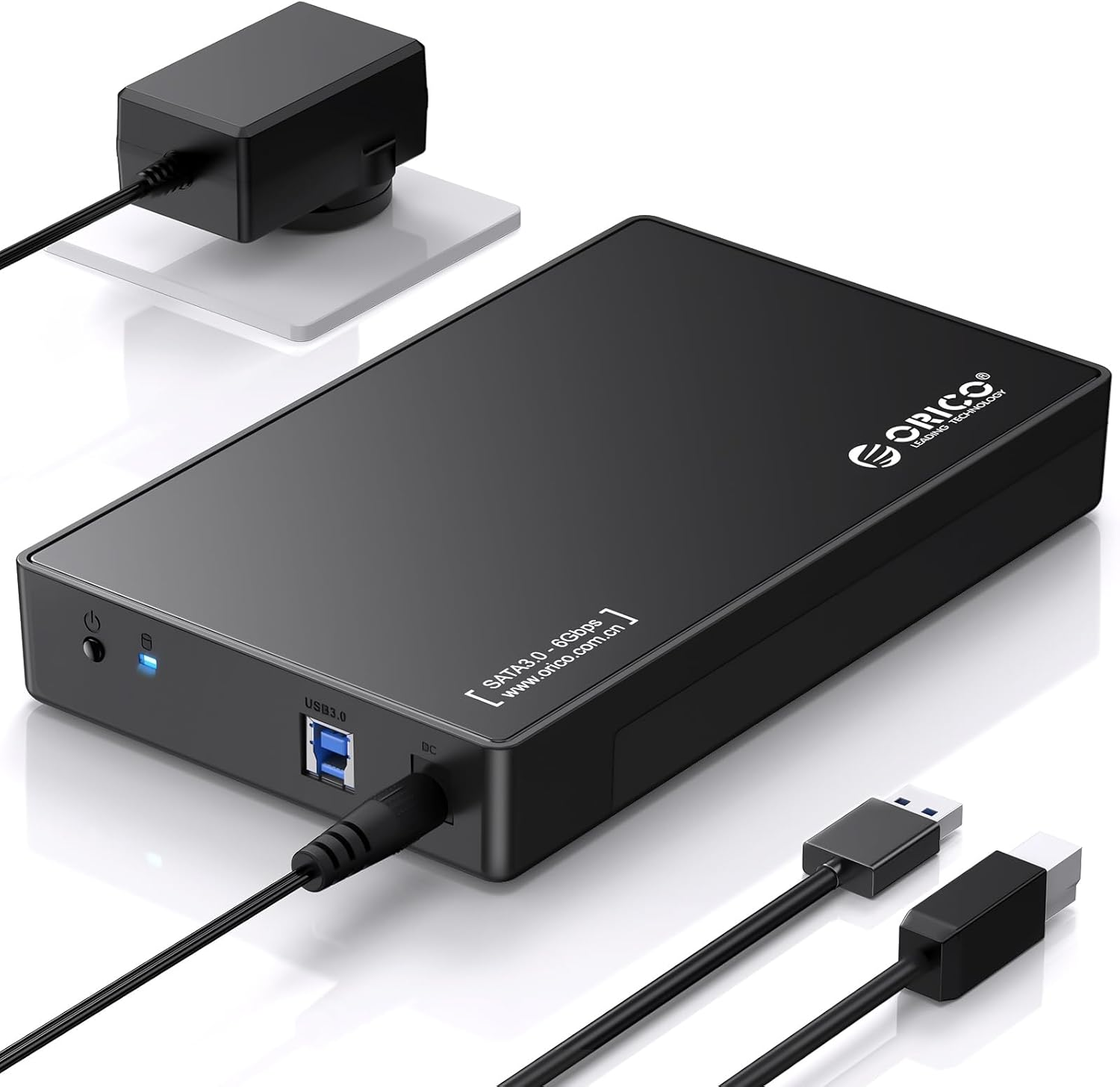 Schwarzes externes Festplattengehäuse mit USB 3.0 Port, Netzteil und Kabeln.