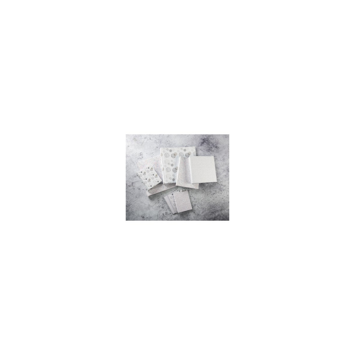 Plusieurs serviettes en tissu blanc avec divers motifs sur fond gris.