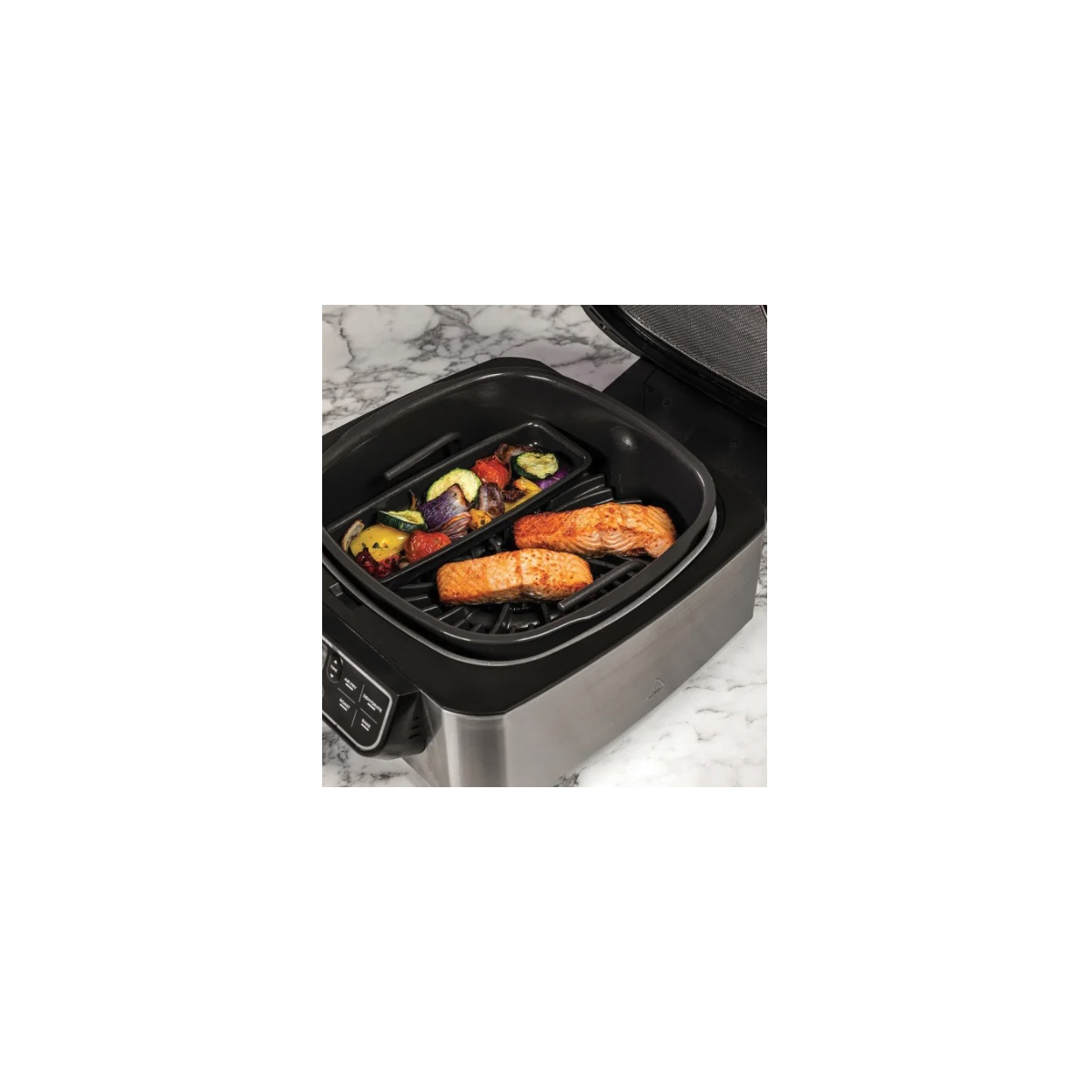Ein Grill mit zwei Lachsfilets und Gemüse in einer Bratpfanne.