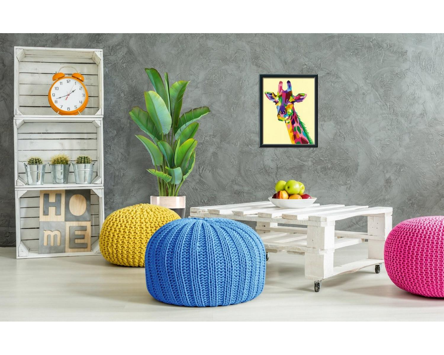 Una stampa pop art colorata di giraffa è appesa sopra un tavolino bianco in pallet con frutta.