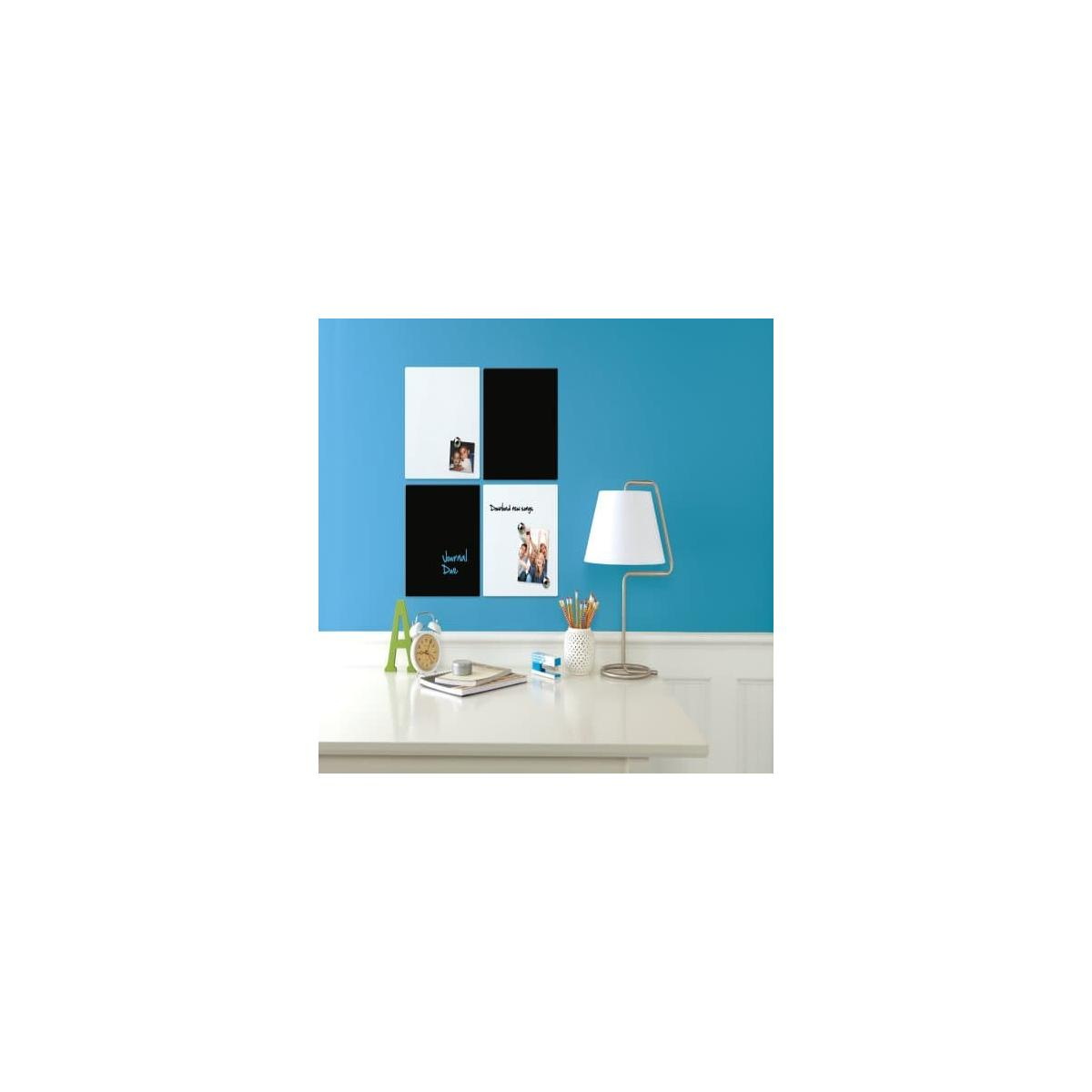 Ein Schreibtisch mit Whiteboards, einer Lampe und Büromaterial vor einer blauen Wand.
