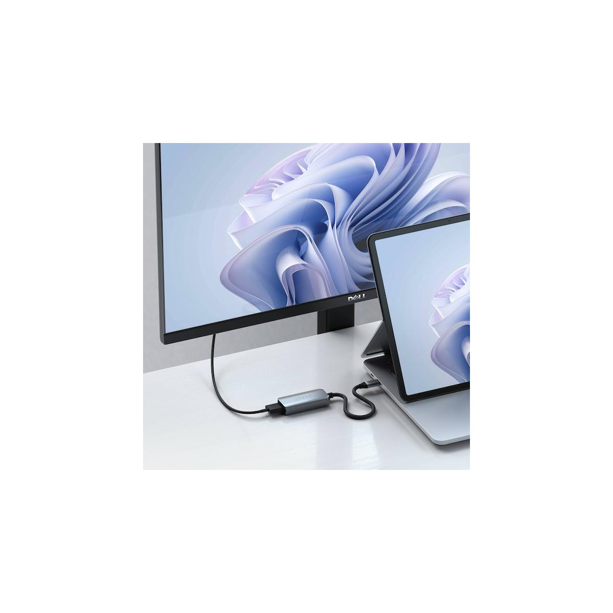 Un monitor e un laptop sono collegati tramite un hub grigio.