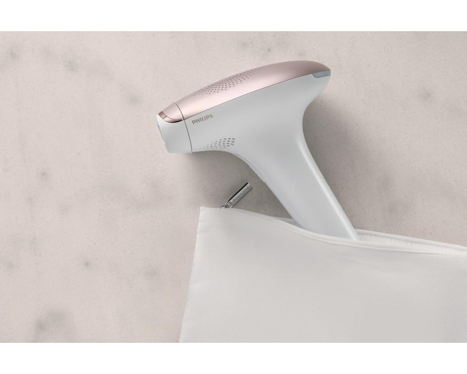 Un dispositivo IPL Philips blanco con acento oro rosa está en una bolsa blanca.