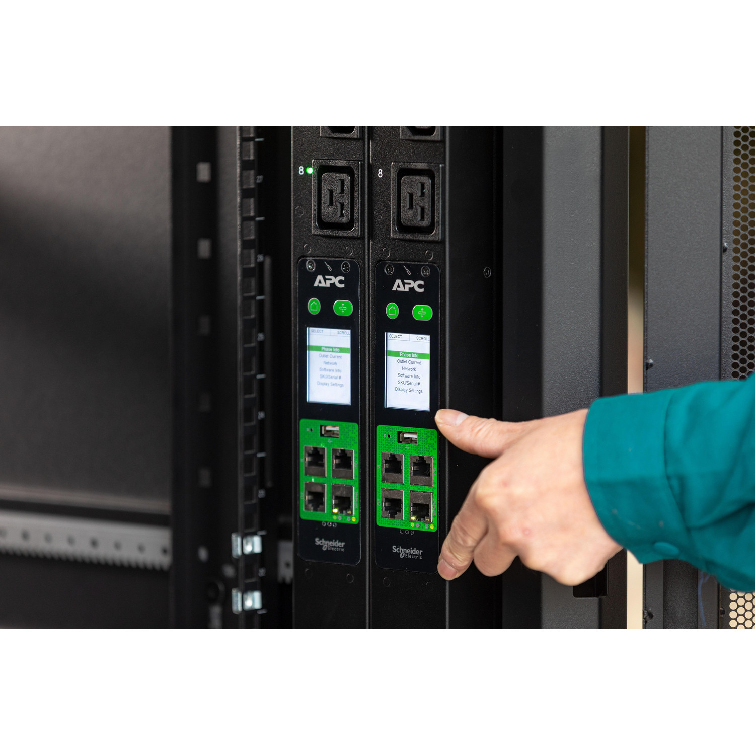 Una mano preme un dispositivo APC in un rack con porte Ethernet.