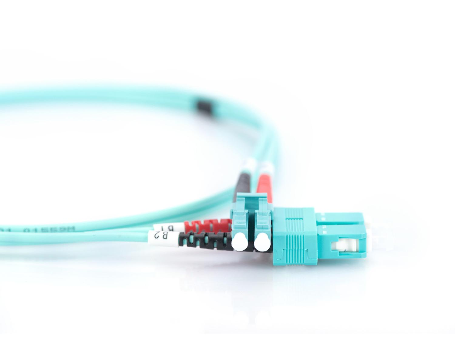 Primo piano di un cavo in fibra ottica turchese con connettori LC e guaine di scarico rosso.