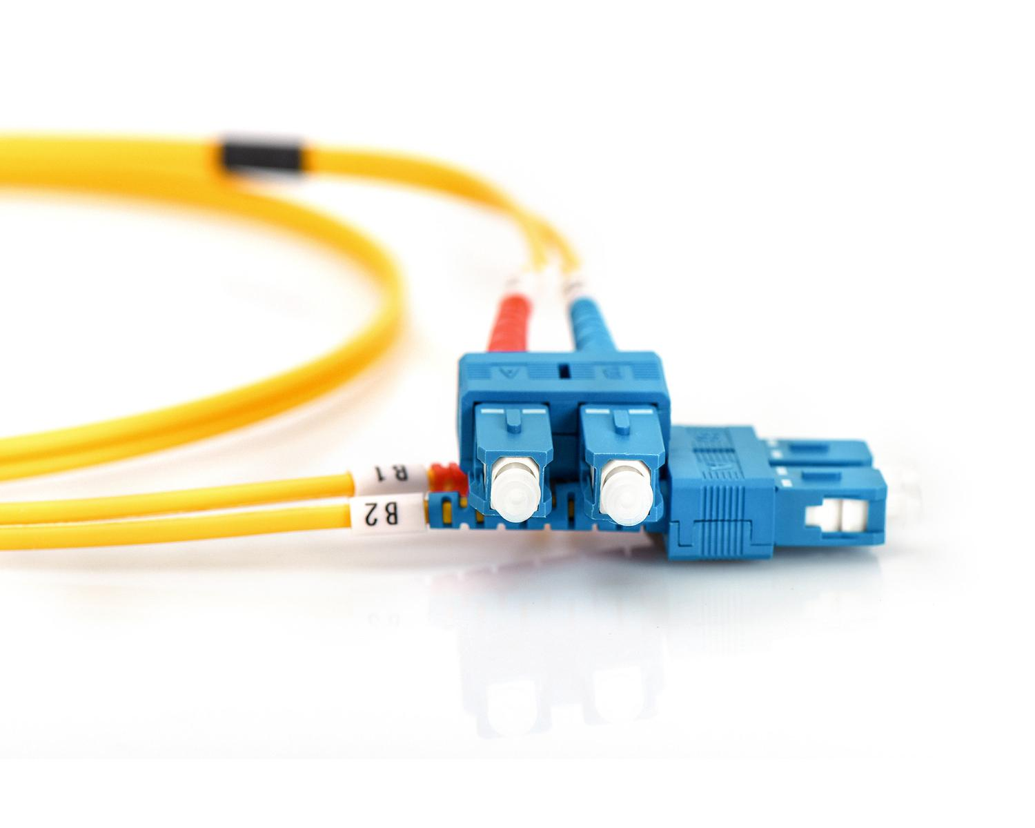 Twee gele glasvezelkabels met blauwe connectoren op witte achtergrond.