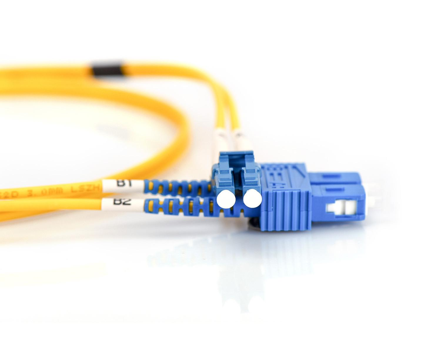 Connettore SC in fibra ottica blu con cavo giallo su sfondo bianco.