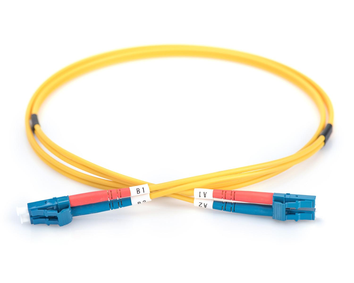 Un cavo in fibra ottica giallo con connettori blu e rossi su sfondo bianco.