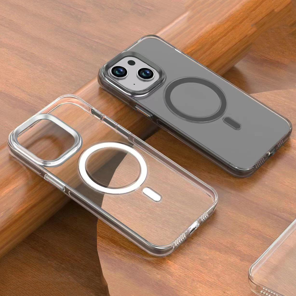 İki şeffaf telefon kılıfı ahşap bir masanın üzerinde yan yana duruyor.