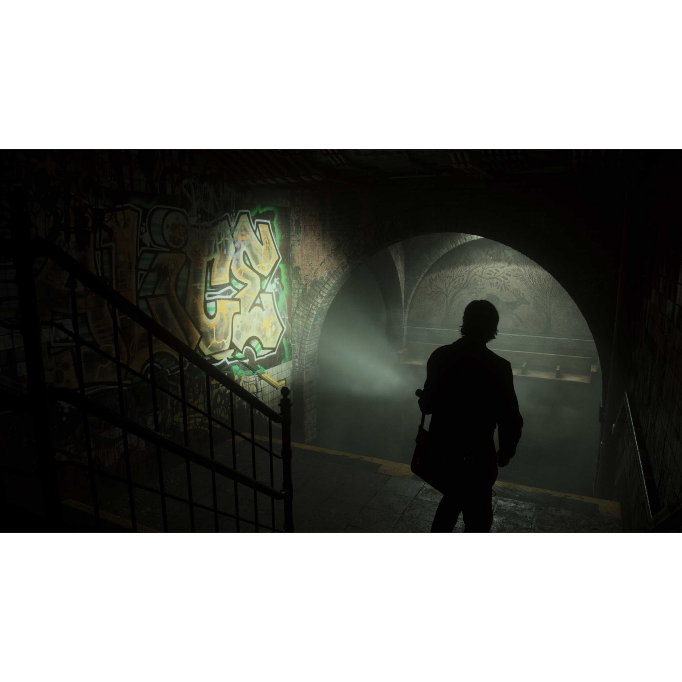 Un uomo con una torcia si trova in un tunnel della metropolitana nebbioso con graffiti sul muro.