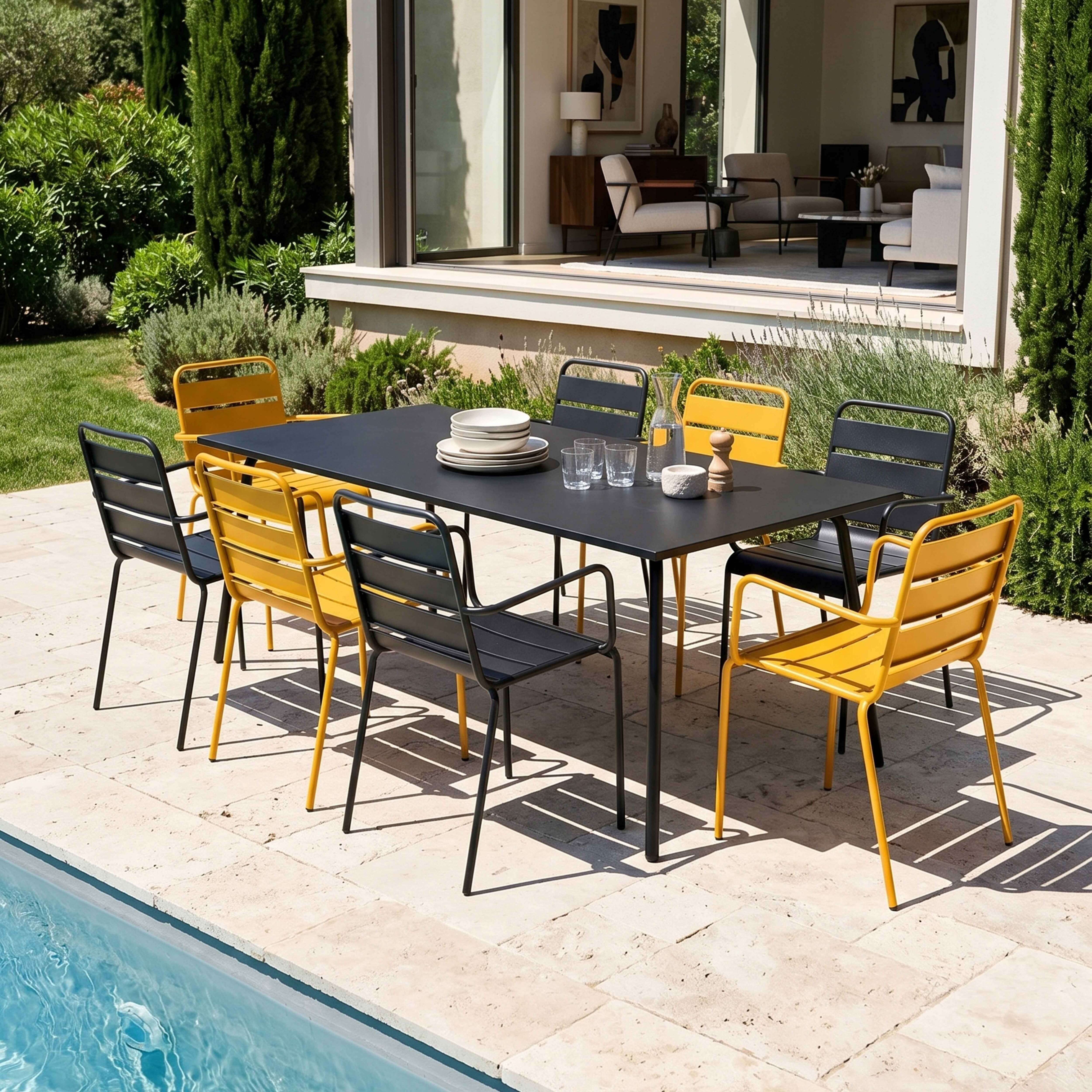 Ein schwarzer Tisch mit gelben und grauen Stühlen auf einer Terrasse neben einem Pool.