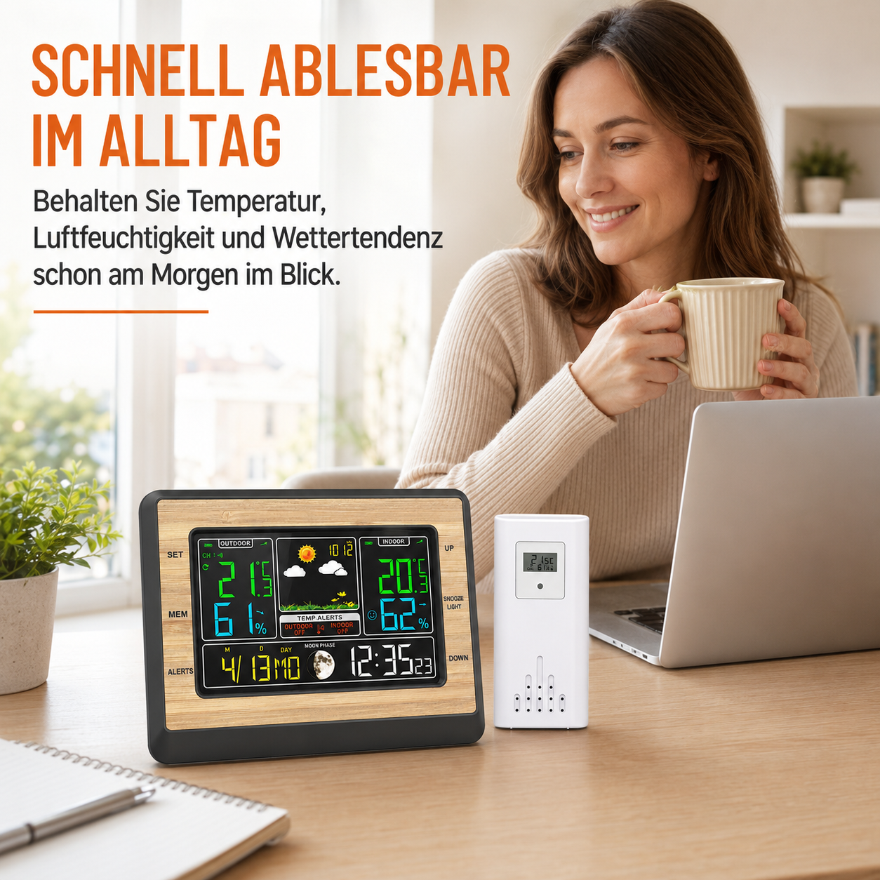 Eine Frau lächelt und hält eine Tasse in der Nähe einer digitalen Wetterstation und eines Laptops auf einem Schreibtisch.