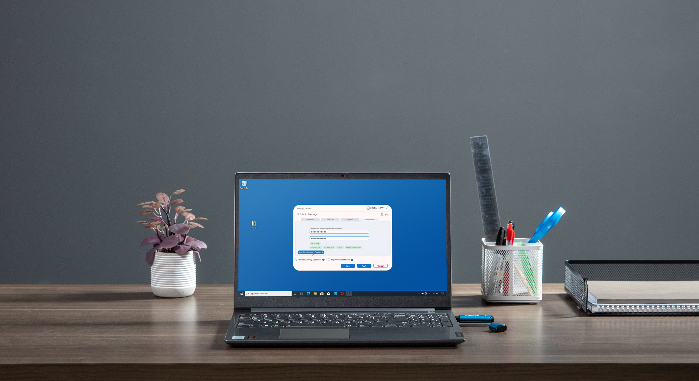 Un portátil en un escritorio muestra una página de configuración, con una planta y material de oficina cerca.