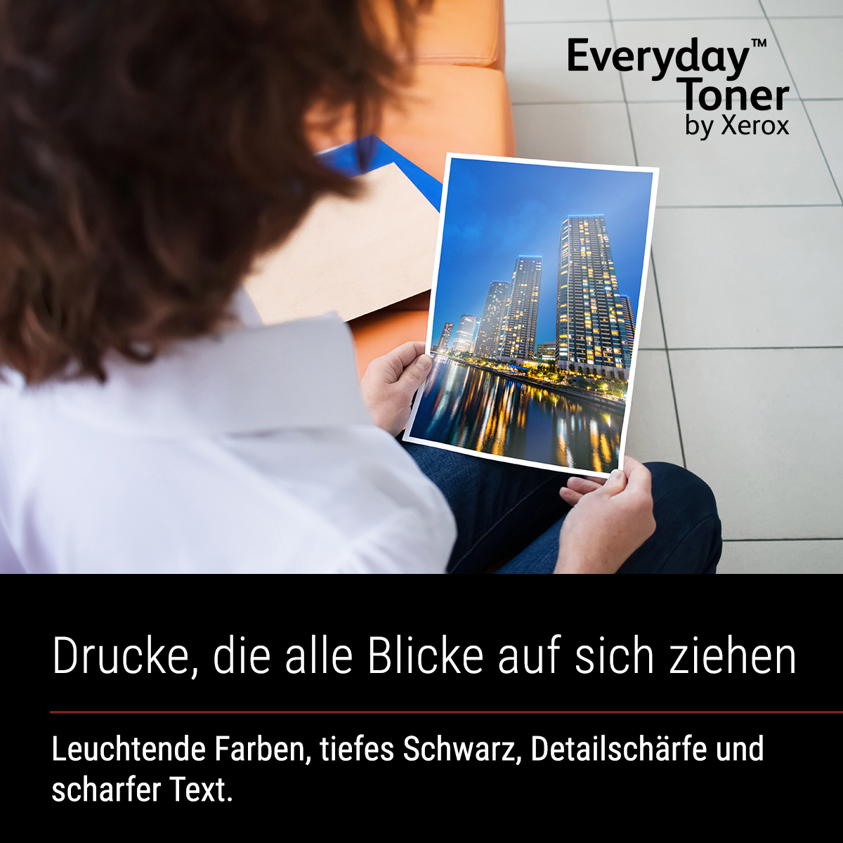 Persoon die een foto vasthoudt van verlichte wolkenkrabbers 's nachts aan het water.